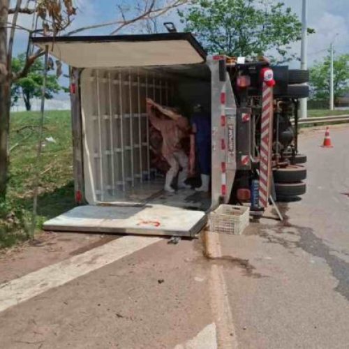 Motorista fica ferido após caminhão carregado de carne tombar no Trevo do Roque