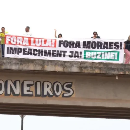 “Fora Lula, Fora Moraes, Impeachment Já”, diz a faixa segurada pela vereadora Sofia Andrade e apoiadores na Avenida Jorge Teixeira